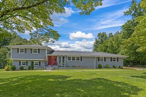 a white house with a red door on a lawn at Mins to Downtown - Huntsville Oasis in Huntsville