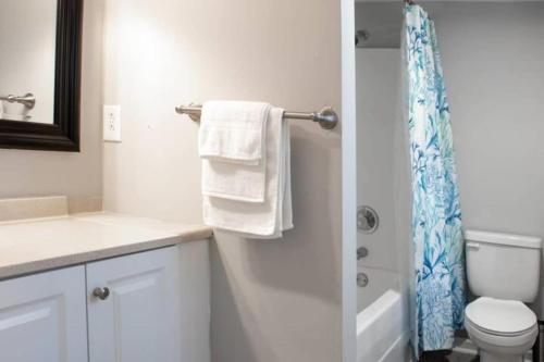 een badkamer met een toilet en een douche met handdoeken bij The Graduation Getaway Near Downtown & Benning in Columbus