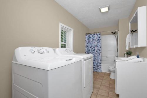 a white bathroom with a sink and a toilet at The Precious Pearl- Close to downtown, Ft Bragg, in Fayetteville