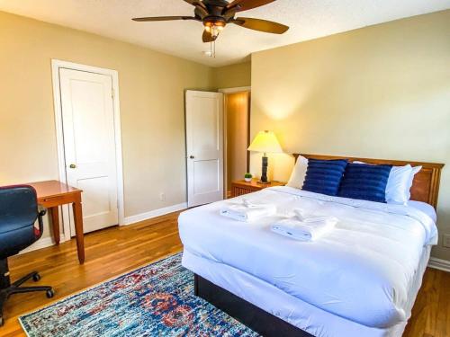 a bedroom with a large white bed and a desk at Bright Bonita Bungalow-Yard-Deck-Medical District in Huntsville