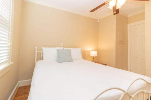 een slaapkamer met een wit bed en een plafondventilator bij Near Downtown&Parks- The Cozy Guest Cottage in Columbus