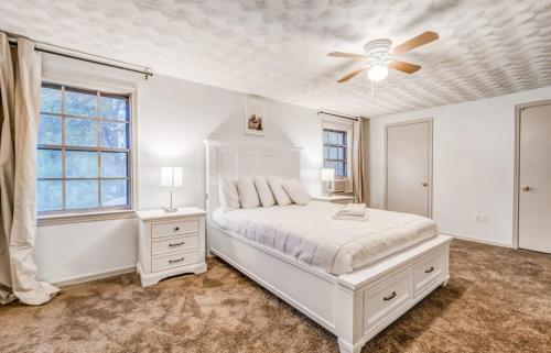 um quarto branco com uma cama e uma ventoinha de tecto em 10 from U of Memphis & Airport- Pinecrest Perch em Memphis