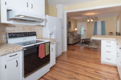 a kitchen with white cabinets and a stove top oven at The Columbus Cottage Mins to Benning Downtown in Columbus
