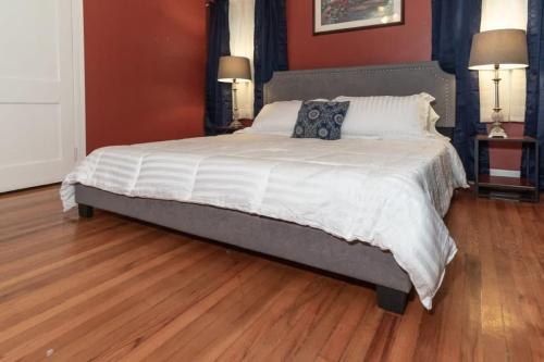 a large bed in a bedroom with a wooden floor at The Columbus Cottage Mins to Benning Downtown in Columbus