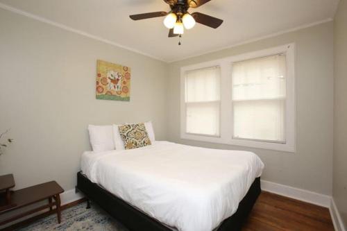 1 dormitorio con cama blanca y ventilador de techo en Forest Lake Hidden Gem 3 Min to Ft Jackson & Shops en Columbia