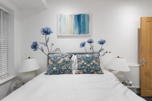 a bedroom with a bed with blue flowers on the wall at Little Venice Maisonette in London