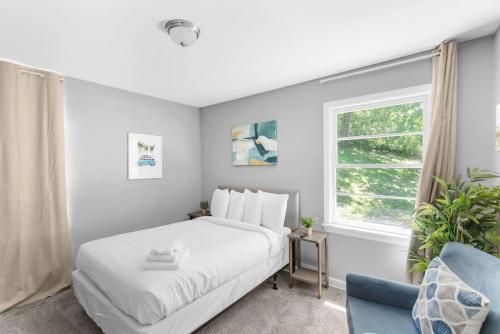 een slaapkamer met een wit bed en een blauwe stoel bij Near Hospital&Dining-Beds on Broadmoor- Both Units in Birmingham