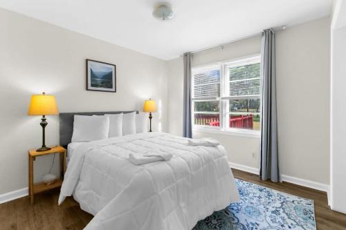 a white bedroom with a bed and a window at Mins to Hospital Airport & Dining- Rooms on Rose in Birmingham