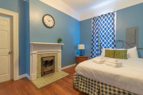 a blue bedroom with a bed and a fireplace at The Sunny Southern Manse Front Walk Downtown in Columbus