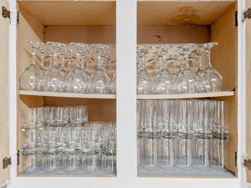 a cabinet filled with glasses sitting on shelves at Mins to USC Hospital Zoo Columbia Duet-Unit B in West Columbia