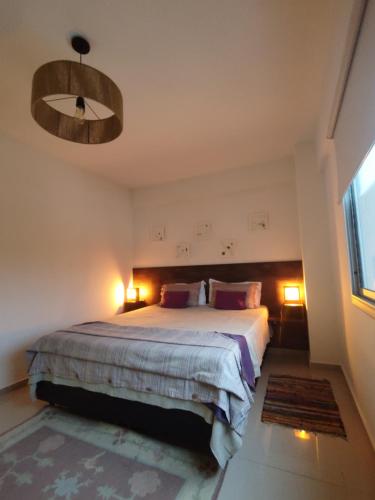 1 dormitorio con 1 cama con 2 lámparas y lámpara de araña en Santiago III en San Juan