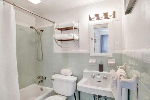 Un baño blanco con inodoro y lavabo. en Charming Midtown Apt - Hannon Hideaway Unit A, en Mobile