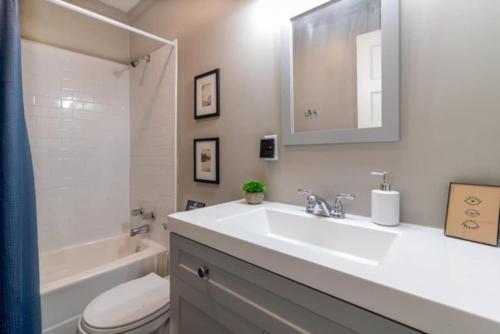a white bathroom with a sink and a toilet at The Delightful Doubles- Unit B- Centrally Located in Columbus