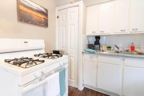 a white kitchen with a stove and a sink at The Delightful Doubles- Unit B- Centrally Located in Columbus