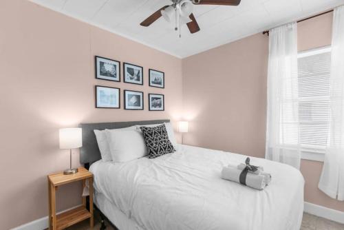 a white bedroom with a bed and a ceiling fan at 10 Mins to Legion Field Stadium- Blushing Bungalow in Birmingham