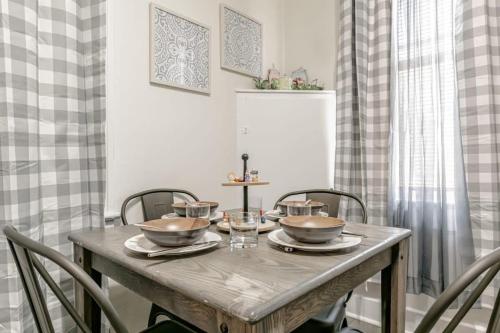 a dining room table with bowls and glasses on it at Charming Midtown Apt - Hannon Hideaway Unit B in Mobile