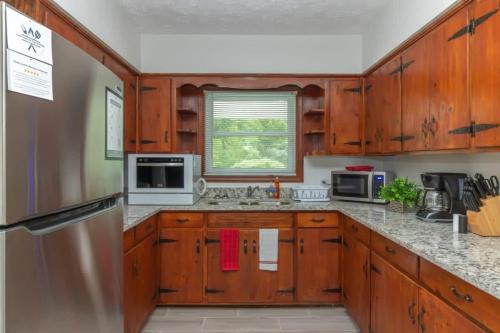 una cucina con armadi in legno e frigorifero in acciaio inossidabile di Near Benning w Fenced Yard- Family Ranch Retreat a Columbus