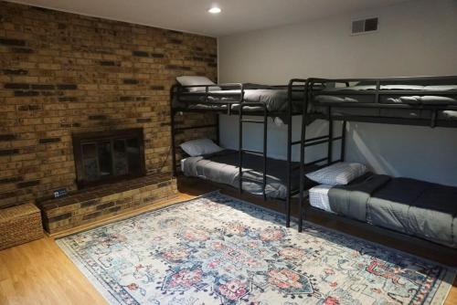Zimmer mit 3 Etagenbetten und einem Kamin in der Unterkunft Mins to River Mountain Park Dining & Shopping in Little Rock