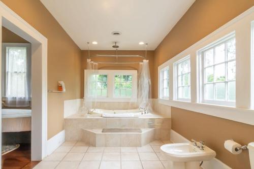 een grote badkamer met een bad en een wastafel bij Goldfinch Mansion Historic Luxury on the Park in Columbus