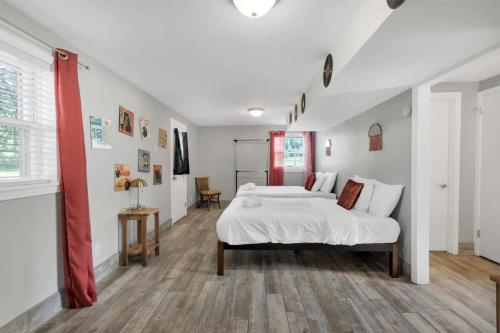 1 dormitorio con cama blanca y cortina roja en The Retro Pad - Large Yard and Foosball Table, en Madison