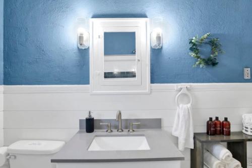 a bathroom with a sink and a blue wall at Charming Midtown Apt - Hannon Hideaway Unit C in Mobile