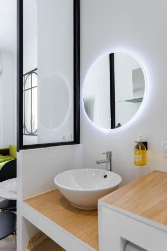 une salle de bain avec un lavabo blanc et un miroir dans l'établissement Suite avec baignoire Balnéo à 4min à pied du Vieux-Port, à Marseille