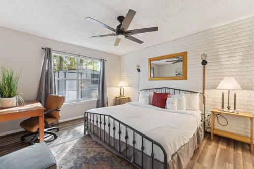 a bedroom with a bed with a ceiling fan and a desk at Wistful on Washington-Moon River District in Savannah