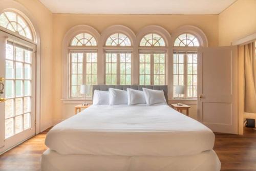 a large white bed in a room with windows at Near Downtown Parks & Museum - Midtown Two-Units in Columbus