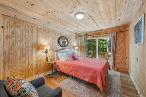 - une chambre avec un lit dans une pièce dotée de murs en bois dans l'établissement Jacob and Ida's Pumpkin Playhouse, à Mentone
