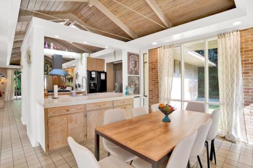 a kitchen and dining room with a wooden table and chairs at Midcentury Modern - Pool & Hot tub - Retro Retreat in Mobile