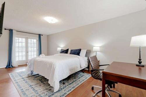 a white bedroom with a bed and a desk and a desk at Soda City Suite in Columbia
