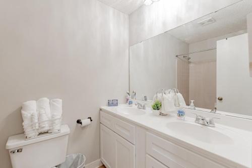 a white bathroom with a sink and a mirror at Soda City Suite in Columbia