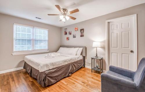 um quarto com uma cama, uma ventoinha de tecto e uma cadeira em Modern Ranch in East Memphis em Memphis