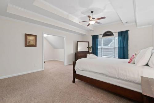 een slaapkamer met een bed en een plafondventilator bij The Beds on Brewster- 15 mins to Ft Campbell in Oak Grove
