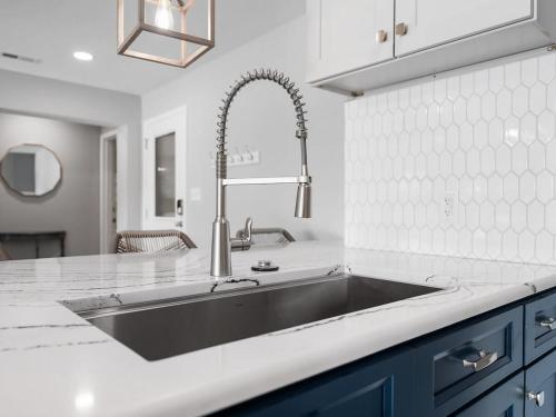 a kitchen with a stainless steel sink and blue cabinets at Stay a Wylie on the Lake in York