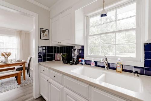 eine weiße Küche mit einem Waschbecken und einem Fenster in der Unterkunft Comfy in Columbia in Columbia
