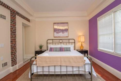 1 dormitorio con cama y pared púrpura en Boho Vibes - Spacious in the Heart of Downtown, en Augusta