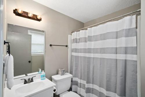 un bagno con un water bianco e una tenda da doccia di The Heart of Merrimack Historic Mansion a Huntsville