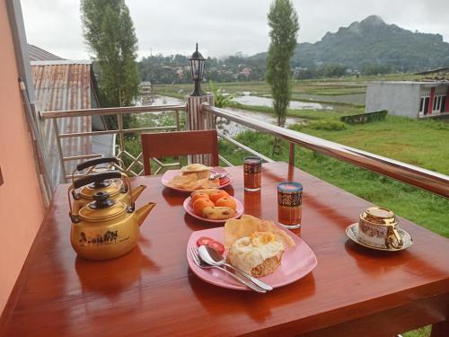 una mesa con platos de comida en el balcón en THE TWINS HOMESTAY, en Rantepao