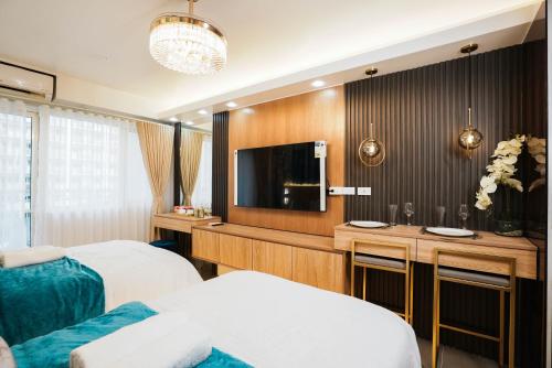 a hotel room with two beds and a flat screen tv at Hawaii Suite by Guest Reservations Manila in Manila