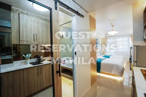 a bathroom with a sink and a bed in a room at Hawaii Suite by Guest Reservations Manila in Manila