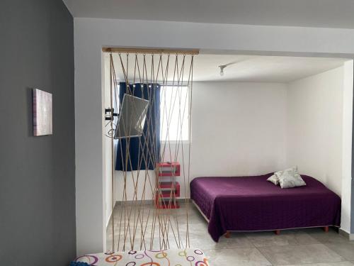 a bedroom with a purple bed and a window at Hospedaje Feria de San marcos 2024 Para 8 Personas in Aguascalientes