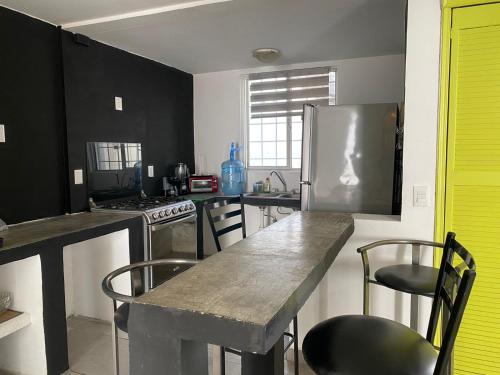 a kitchen with black cabinets and a table and chairs at Hospedaje Feria de San marcos 2024 Para 8 Personas in Aguascalientes