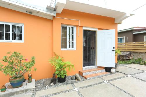 a small orange house with a white door at Home Away From Home in Kingston
