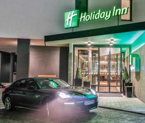 a car parked in front of a hilton inn at Holiday Inn - Villingen - Schwenningen by IHG in Villingen-Schwenningen