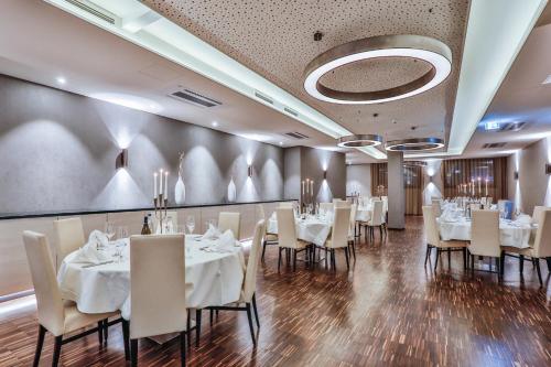 a dining room with white tables and chairs at Holiday Inn - Villingen - Schwenningen by IHG in Villingen-Schwenningen