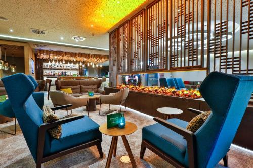 eine Lobby mit Stühlen, Tischen und einer Bar in der Unterkunft Holiday Inn - Villingen - Schwenningen, an IHG Hotel in Villingen-Schwenningen