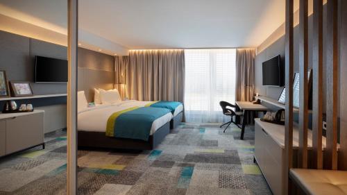 a hotel room with a bed and a desk at Holiday Inn - Villingen - Schwenningen by IHG in Villingen-Schwenningen
