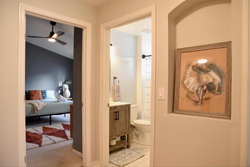 a hallway with a bathroom with a painting of a horse at Artisan's Retreat - Poolside Paradise Near Disney in Orlando