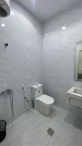 a white bathroom with a toilet and a sink at منتجع لي فارد in Taif